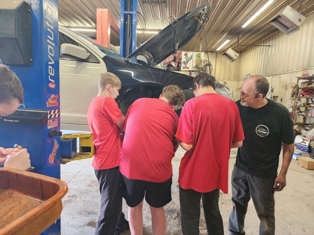 Students learning about working on car for work experience