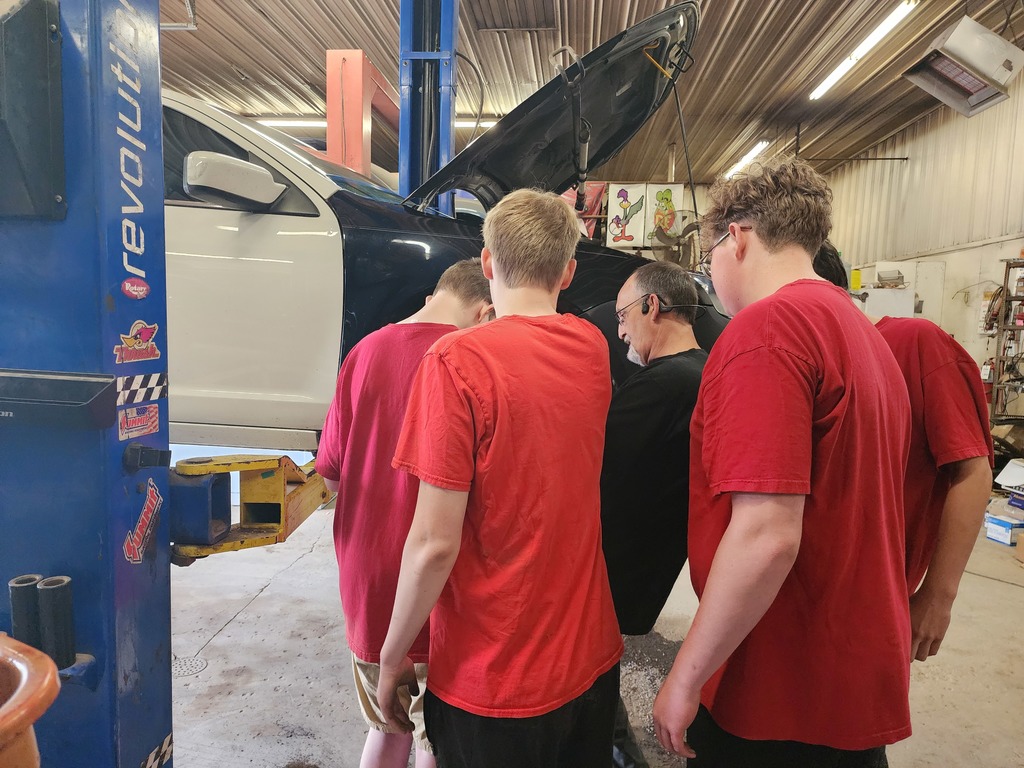 Students learning about working on car for work experience
