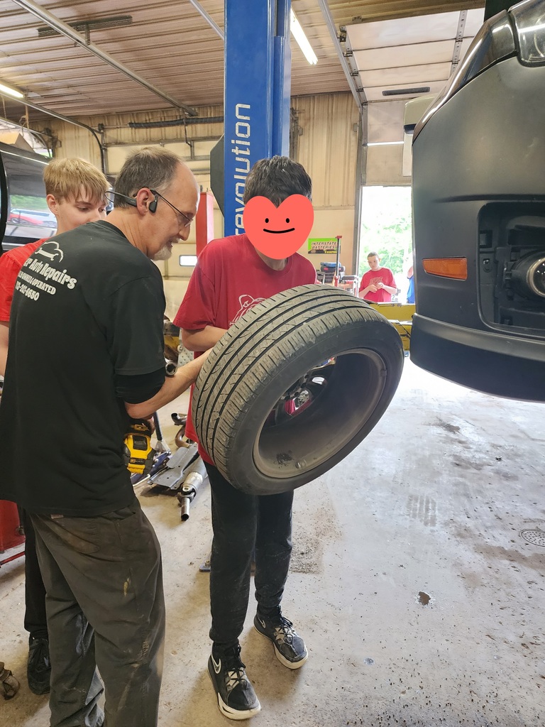 Students learning about working on car for work experience