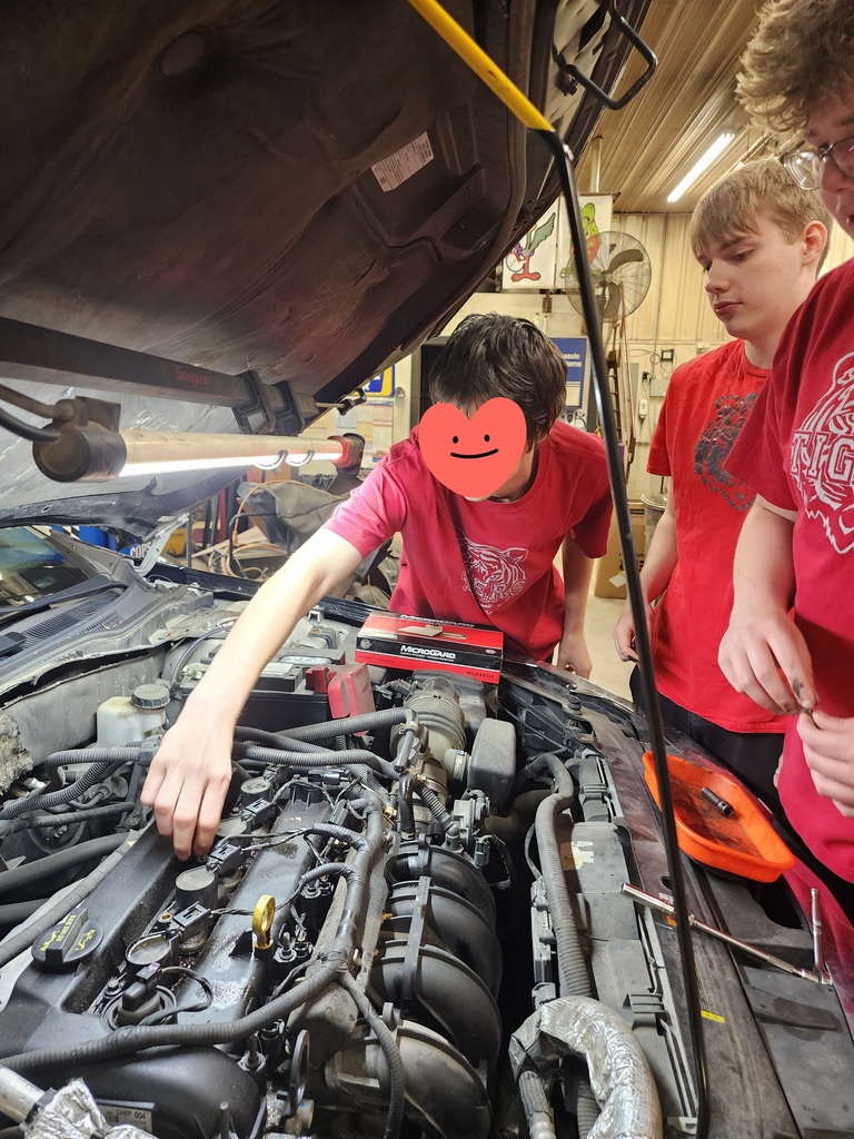 Students learning about working on car for work experience