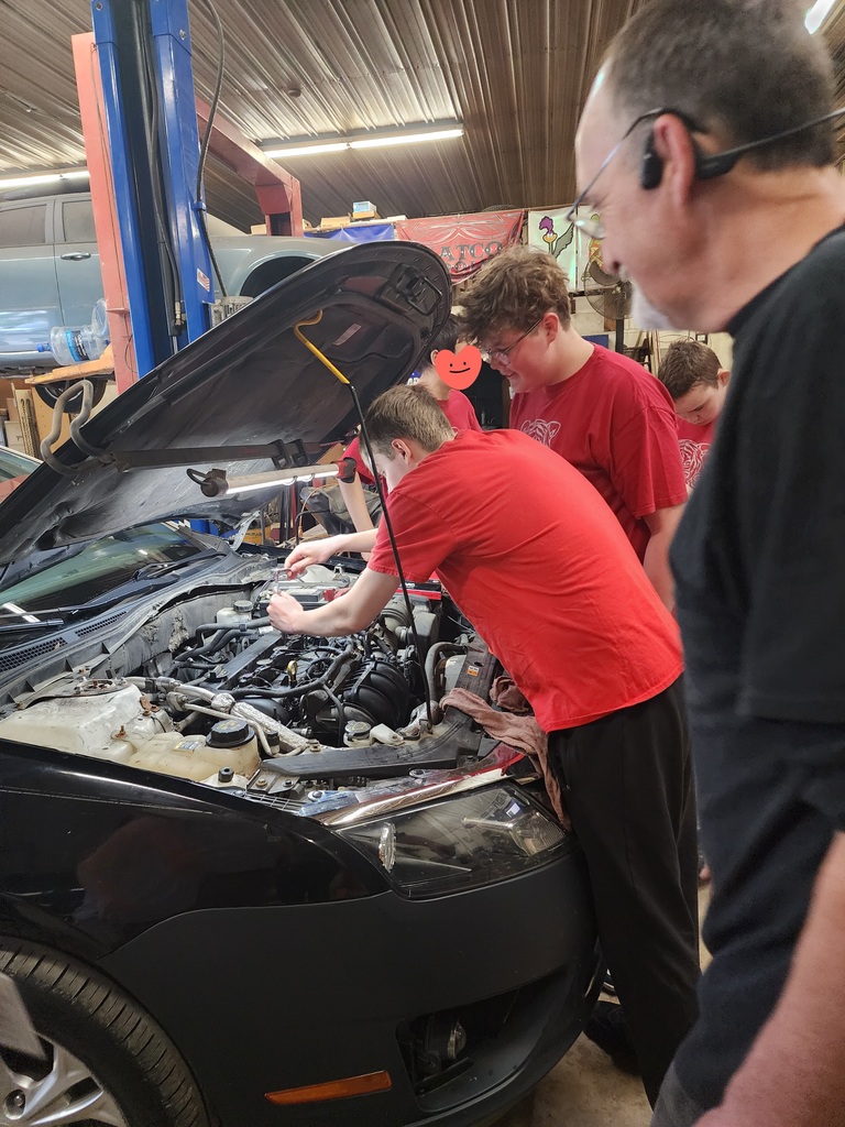 STudents engaged in working on car for work experience
