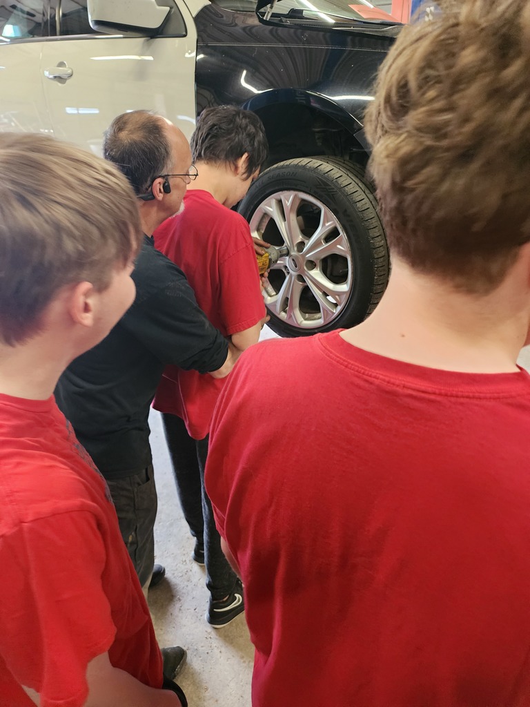 Students learning about working on car for work experience