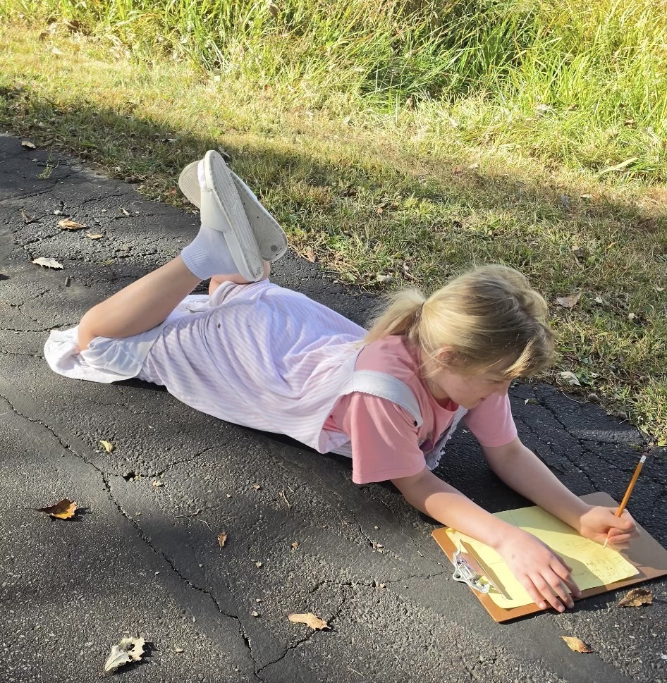 Students spent time in a “sit spot” to jot down what they could hear, feel, see, and smell. They used their notes for a piece on descriptive writing.