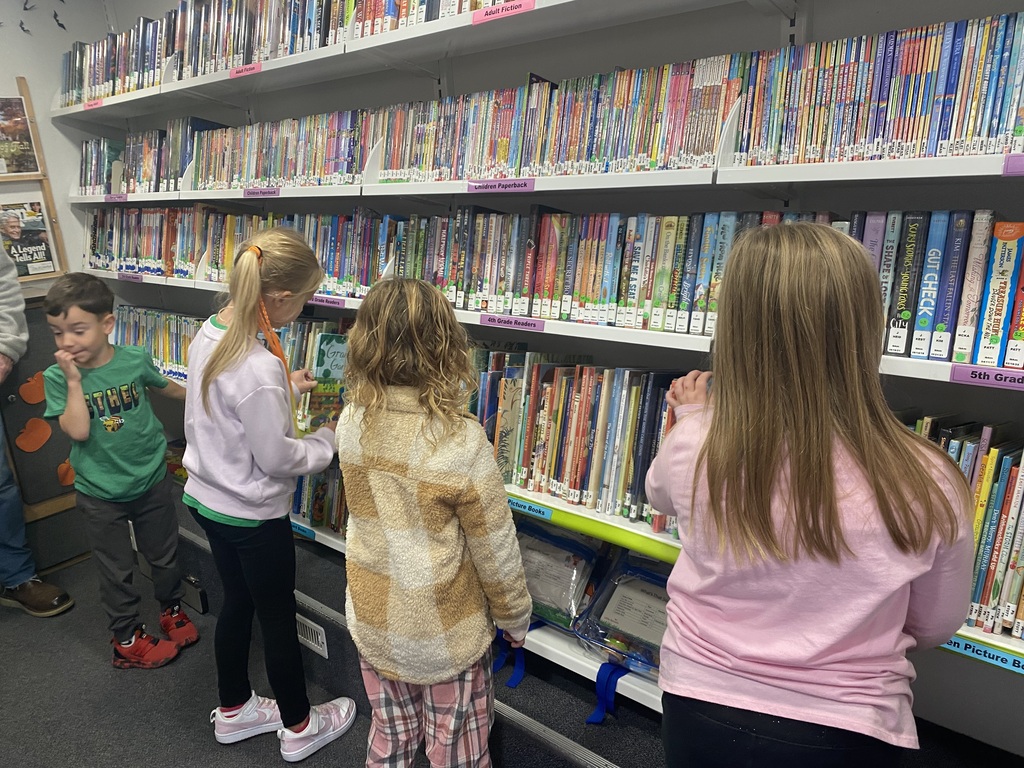 1st Graders looking through shelves of books