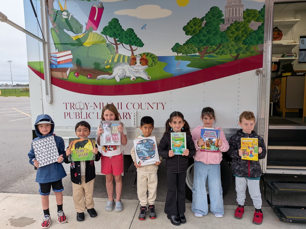 First Graders holding up their books they selected from the bookmobile
