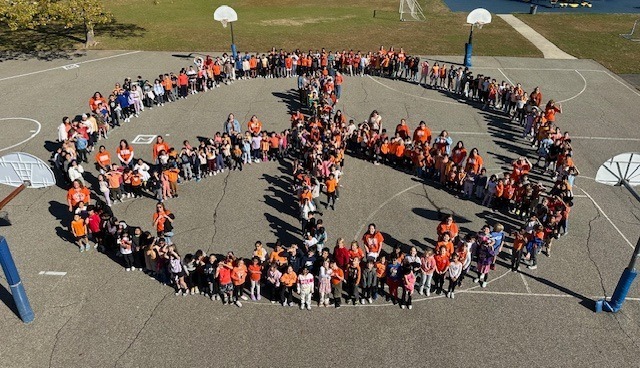students in forming a peace symbol out on the playground