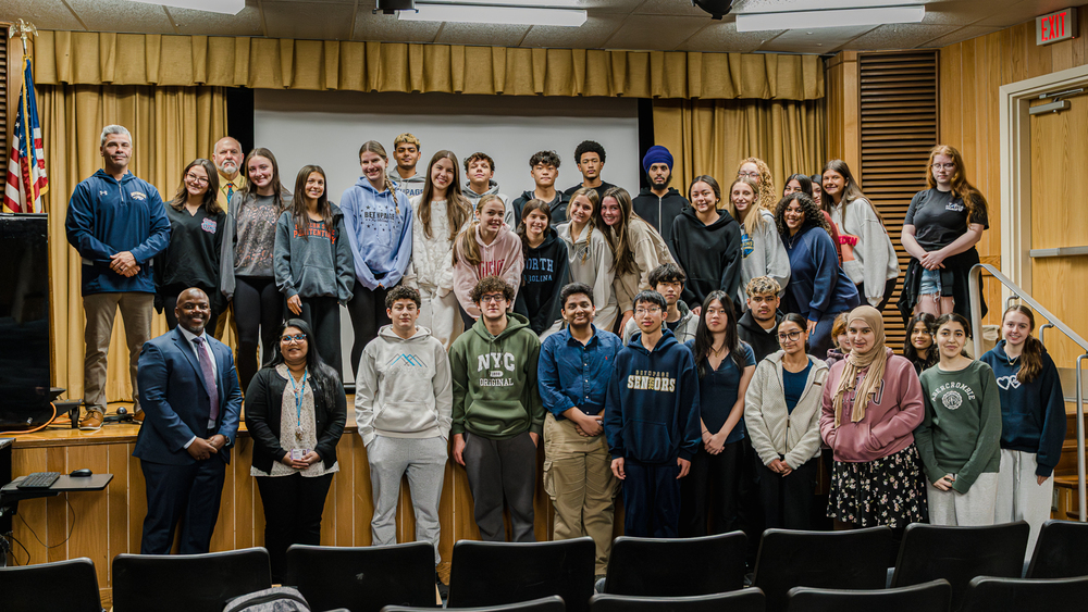 Students taking group photo with healthcare professionals and educators.