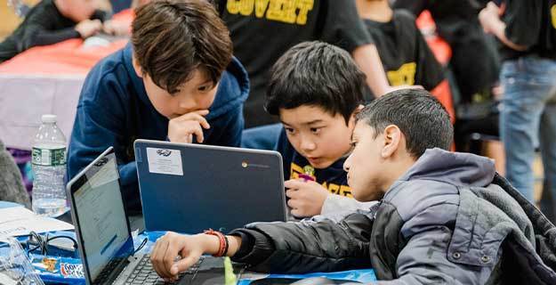 Students looking at laptop.