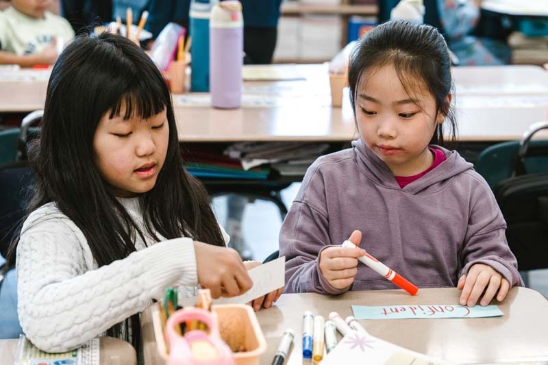 Students coloring with markers.