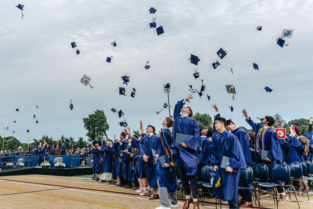 Graduating seniors throwing their caps into the air.