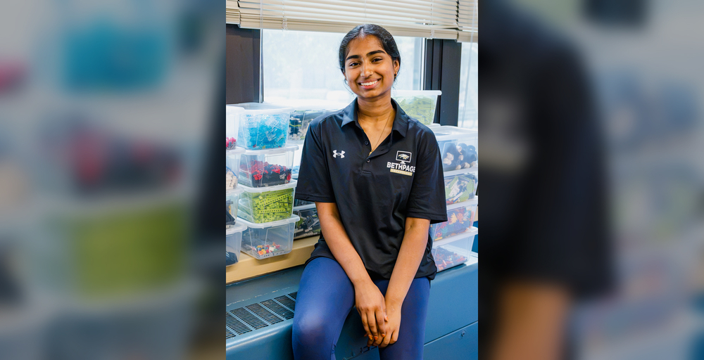 young woman in black shirt sitting by storage containers