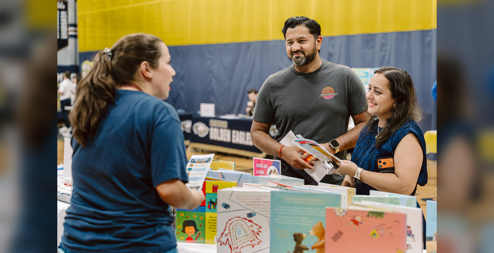People talking at book fair table