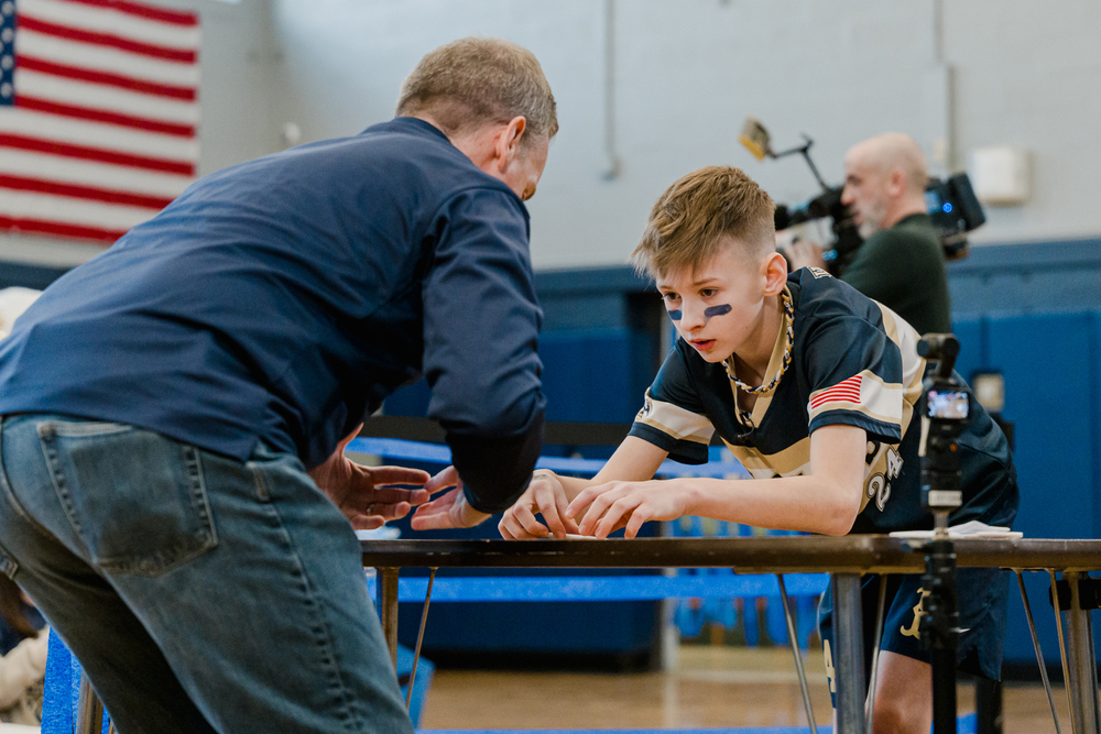 Student and teacher leaned over desk.