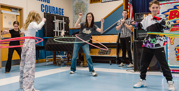 Students hula hooping in gymnasium