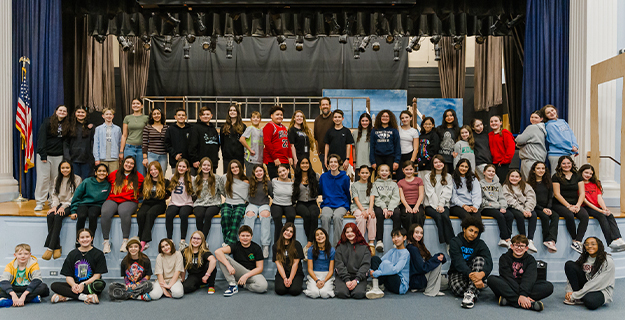High school students standing together on stage.