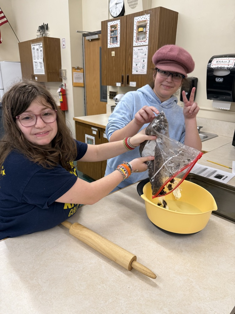 two students mixing ingredients together