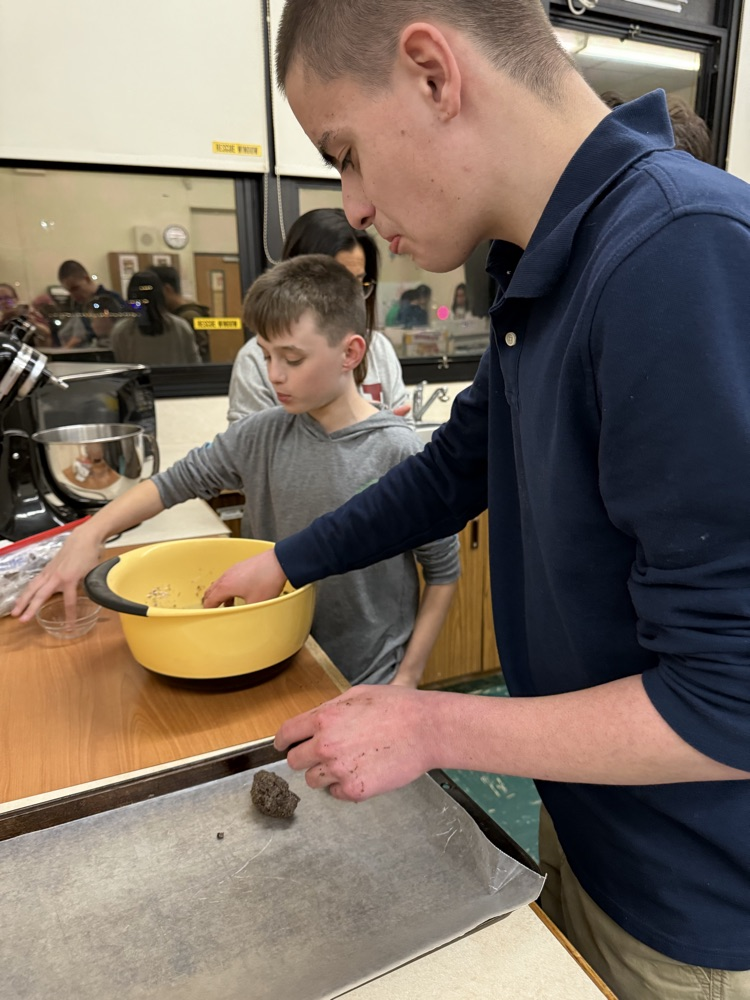 students rolling dough and placing them on an oven tray