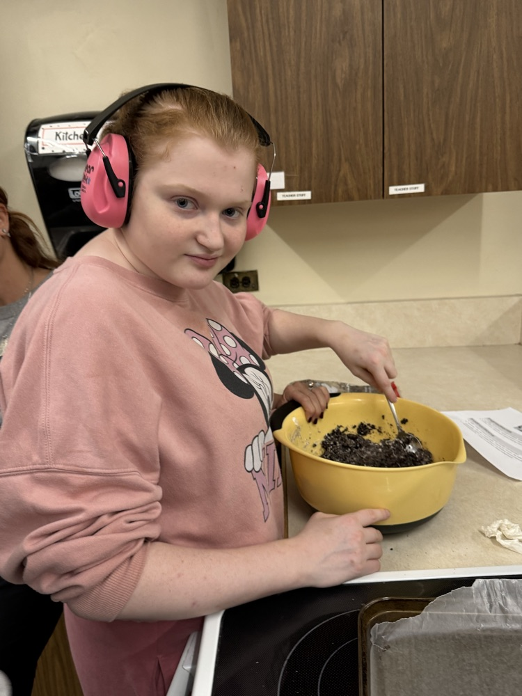 student mixing ingredients