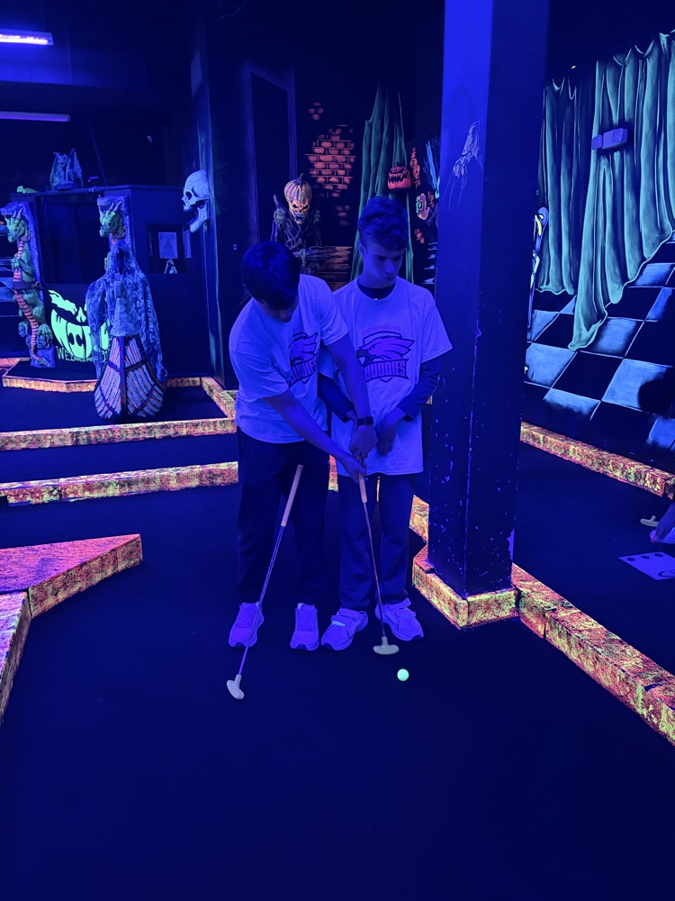 buddies on mini golf course taking picture