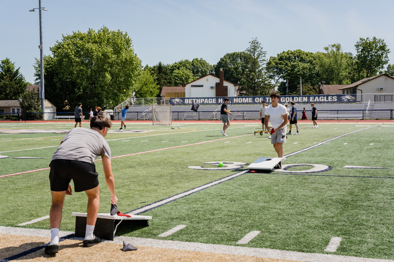 students playing cornhole on field