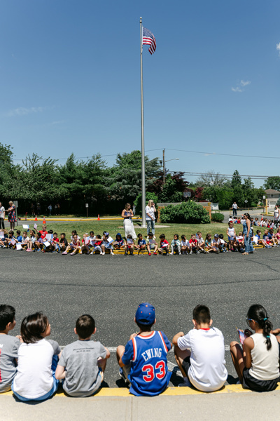 children seated on pavement gathering event