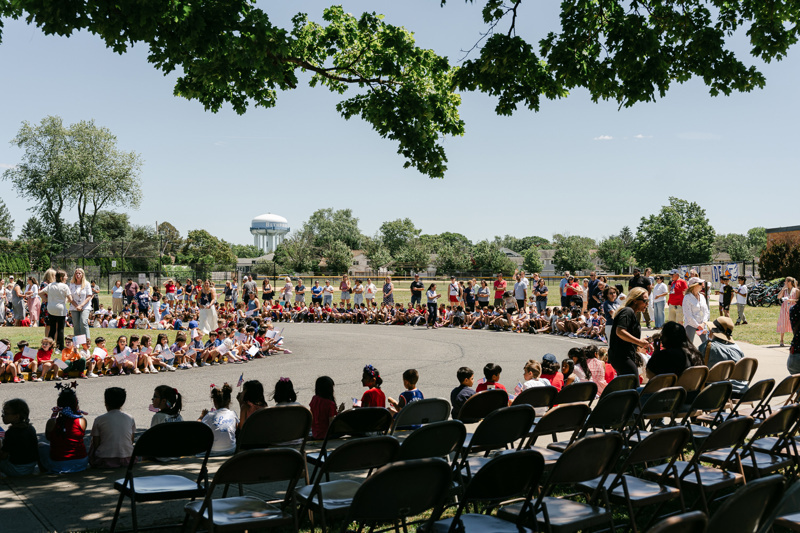children seated on pavement gathering event