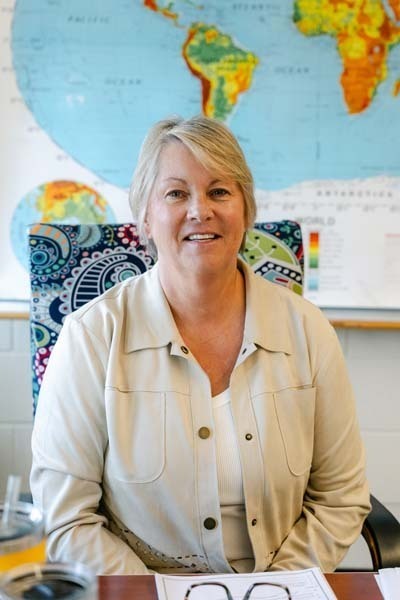 Photo of teacher sitting at desk.
