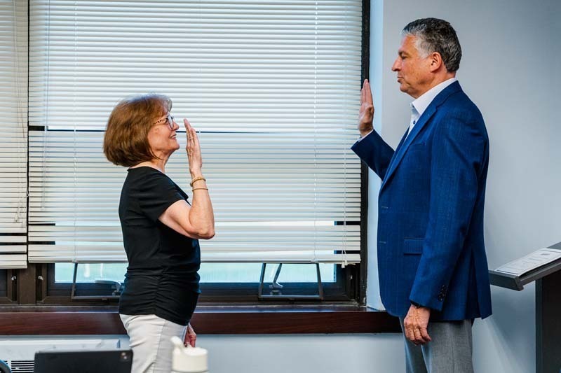 Board member being sworn in.