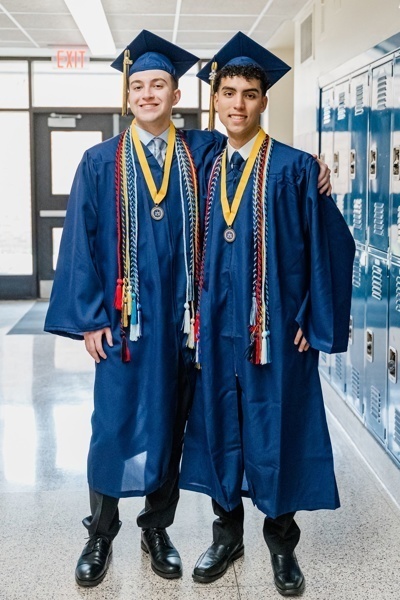 two graduates in blue caps and gowns