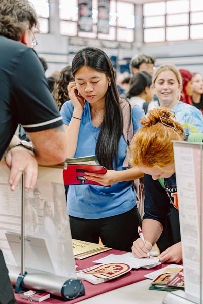 Students speaking to each other at college fair.
