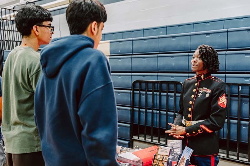 Students speaking to each other at college fair.