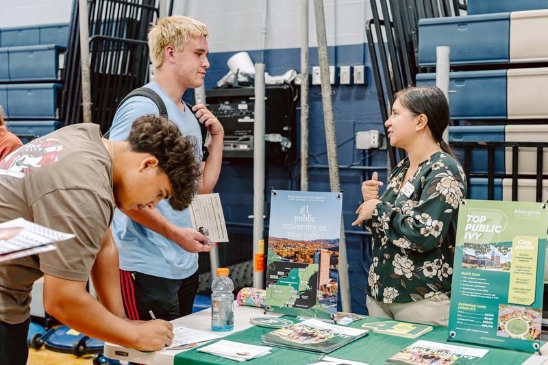 Students speaking to each other at college fair.