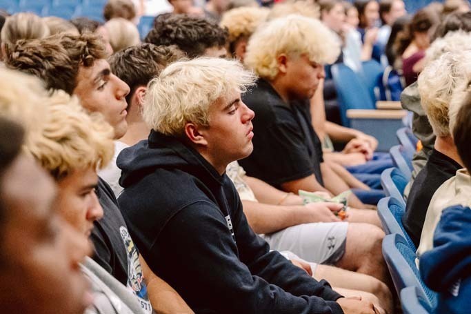 Students listening in auditorium.
