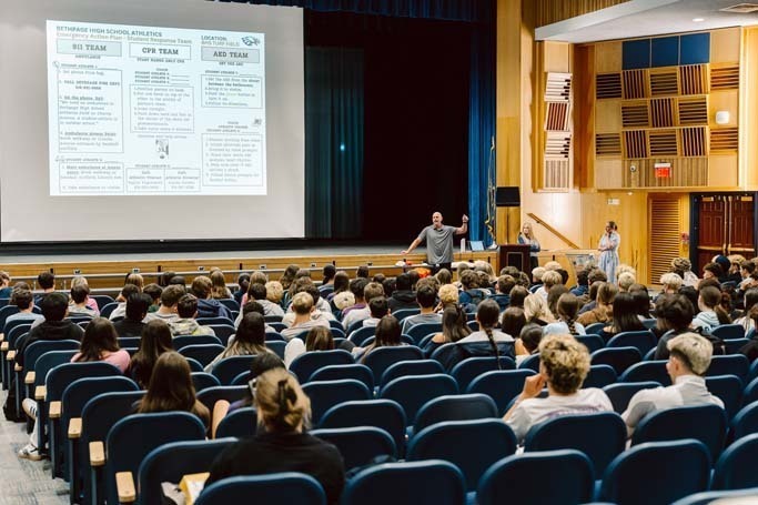 Students listening in auditorium.