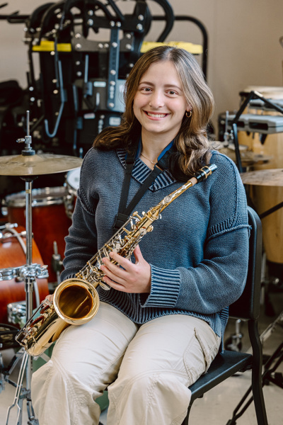 Person holding saxophone sitting in chair