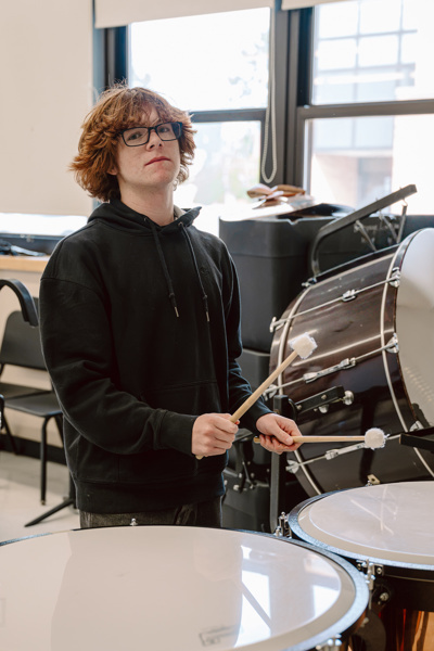 Person playing drums in a music room