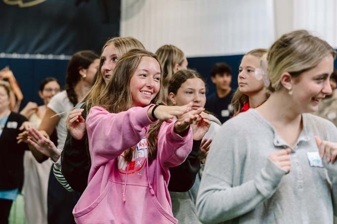 Students smiling in gymnasium.