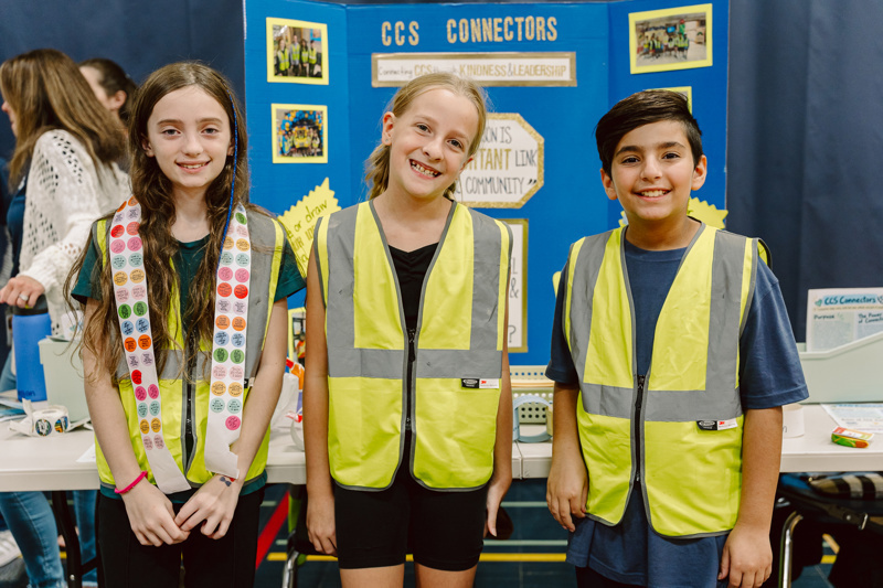 Three people wearing yellow vests