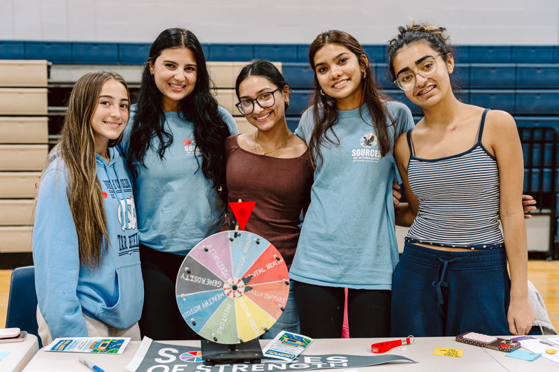 Group of people next to prize wheel