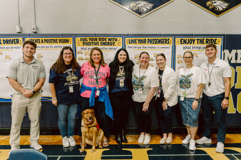 Group of people with dog and posters