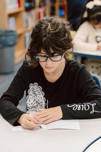 Student writing in library.