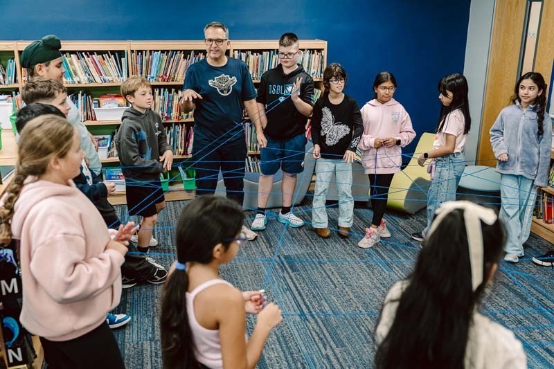 Students and teachers gathered in circle in library.