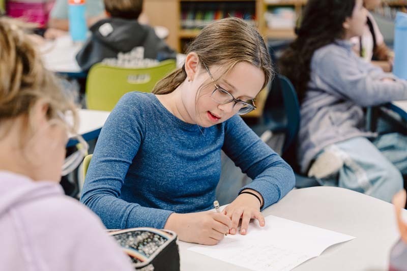 Student writing in library.