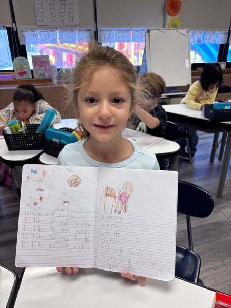 Student writing at desk.