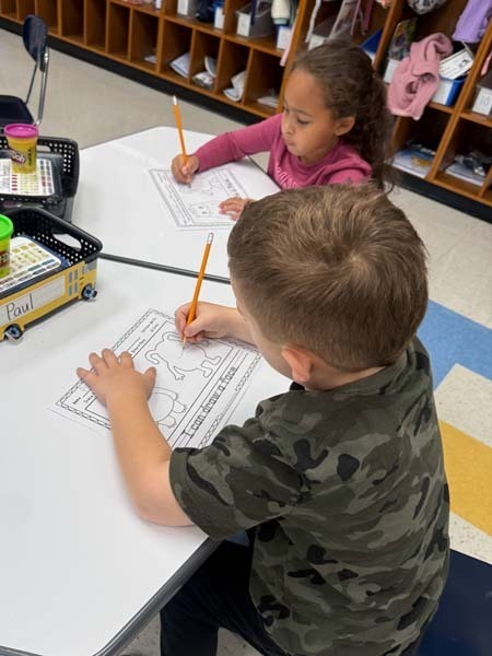 Student writing at desk.