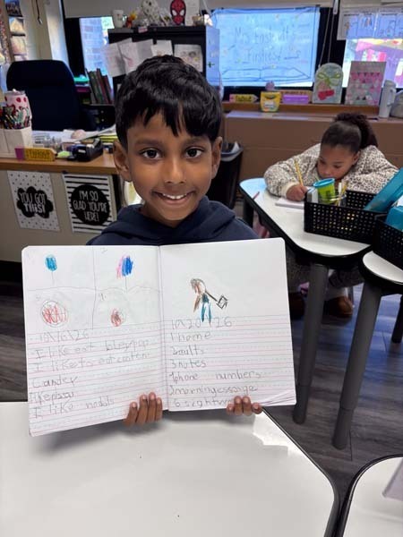 Student writing at desk.