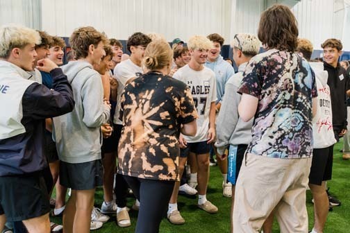 Students taling to each other in large group.