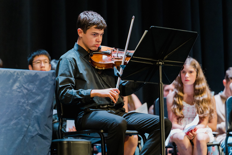 students on stage performing instruments
