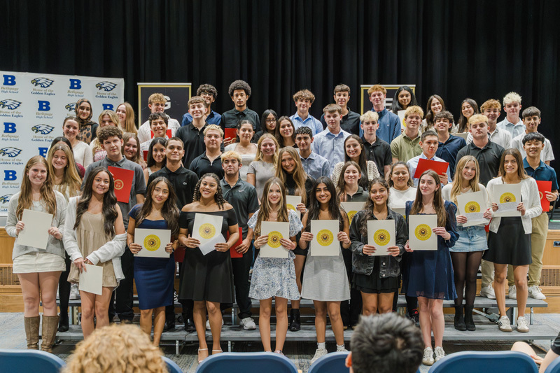 group shot of students with awards on stage