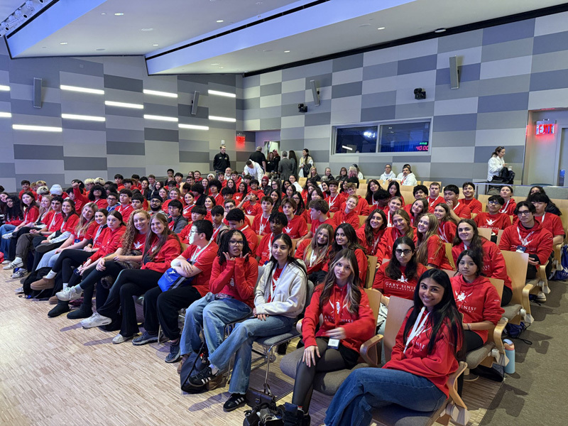students sitting in chairs all dressed in red